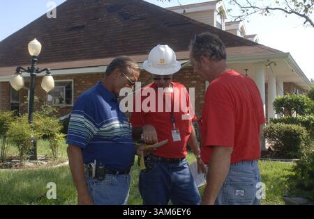 27 settembre 2005 - Stati Uniti - KRT LA NOTIZIA degli Stati Uniti SLUGGED: WEA-STORMS-TARPS KRT FOTOGRAFIA DI IAN MCVEA/FORT WORTH STAR-TELEGRAM (DALLAS OUT) (settembre 29) subappaltatore della difesa LJC Gary German, Left, parla con i rappresentanti del corpo degli ingegneri dell'esercito degli Stati Uniti David Rogers (centro) e Dennis Brown mentre valutano i danni al tetto alle case a Metairie, Louisiana martedì 27 settembre 2005. Gli appaltatori che lavorano con la FEMA e il corpo degli ingegneri dell'esercito degli Stati Uniti stanno iniziando a coprire i quartieri con i tetti blu. I rappresentanti del corpo stimarono che a Kenner e Metairie circa 60-70 case hanno la diga del tetto Foto Stock