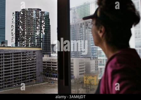 24 ott. 2005 - USA - NO MAGS, NO VENDITE FINO AL 11/8/05 --KRT US NEWS STORY SLUGGED: WEA-WILMA KRT PHOTOGRAPH DI NURI VALLBONA/MIAMI HERALD (SOUTH FLORIDA SUN-SENTINEL OUT E ORLANDO SENTINEL OUT) (24 ottobre) MIAMI, FL- Carmen Rodriguez mostra l'edificio danneggiato di Greenberg Traurig su Brickell Avenue a Miami, Florida, lunedì 24 ottobre 2005, dal decimo piano del suo appartamento, dopo l'uragano Wilma. (lj) 2005 (immagine di credito: © Nuri Vallbona/mct/ZUMAPRESS.com) Foto Stock