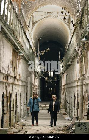 23 novembre 2004 - Stati Uniti - KRT US NEWS STORY SLUGGED: PRISON KRT PHOTOGRAPH BY GERALD S. WILLIAMS/PHILADELPHIA INQUIRER (novembre 30) Sally Elk, direttore esecutivo Eastern State Penitentiary Historic Site, Left, e Cindy Wanerman Walk Through Cell Block 7, il sito della sinagoga tra le rovine dell'Eastern State Penitentiary, 23 novembre 2004, a Philadelphia, Pennsylvania. (lj) 2005. (Immagine di credito: © Gerald S. Williams/mct/ZUMAPRESS.com) Foto Stock