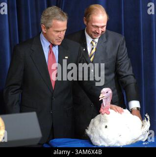 22 novembre 2005 - Stati Uniti - KRT LA NOTIZIA degli Stati Uniti È STATA BLOCCATA: BUSH-TURKEY FOTO del KRT DI GEORGE BRIDGES/KRT (22 novembre) WASHINGTON, DC -- il presidente George W. Bush dà una pacca a Marshmallow, la turchia che ha ricevuto un perdono presidenziale per il Ringraziamento martedì 22 novembre 2005, presso l'Eisenhower Executive Office Building vicino alla Casa Bianca. A destra c'è James Trites che ha cresciuto Marshmallow. (gsb) 2005 (immagine di credito: © George Bridges/mct/ZUMAPRESS.com) Foto Stock