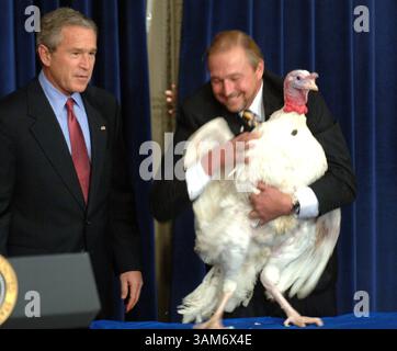 22 novembre 2005 - Stati Uniti - KRT LA NOTIZIA americana È BLOCCATA: BUSH-TURKEY FOTO KRT DI GEORGE BRIDGES/KRT (22 novembre) WASHINGTON, DC -- il presidente George W. Bush guarda come l'agricoltore turco James Trites posiziona Marshmallow il turco che ha ricevuto il perdono presidenziale per il Ringraziamento martedì 22 novembre 2005, presso l'Eisenhower Executive Office Building vicino alla Casa Bianca. (gsb) 2005 (immagine di credito: © George Bridges/mct/ZUMAPRESS.com) Foto Stock