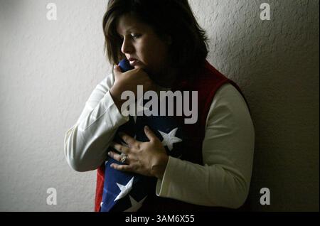 22 novembre 2005 - Stati Uniti - NIENTE MAGS, NESSUNA VENDITA -- NOTIZIA KRT USA BLOCCATA: WARSWOUNDS KRT FOTO DI LARA SOLT/DALLAS MORNING NEWS (8 dicembre) Stefanie Pelkey detiene la bandiera data al funerale di suo marito, il capitano Michael Pelkey, che si è suicidato poco dopo essere stato diagnosticato un disturbo post traumatico da stress dopo aver prestato servizio in Iraq. Pelkey è mostrato a Spring, Texas, nel novembre 2005. (gsb) 2005 (immagine di credito: © Lara Solt/mct/ZUMAPRESS.com) Foto Stock