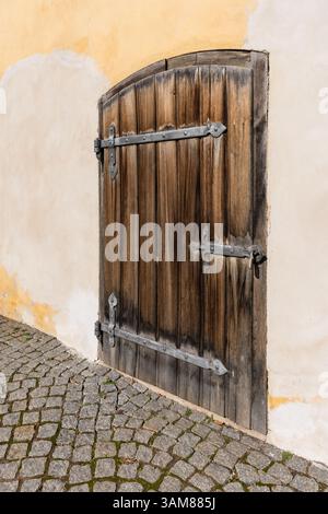 Vecchia porta in legno con cerniere metalliche su pareti in gesso, architettura storica nella Repubblica Ceca Foto Stock