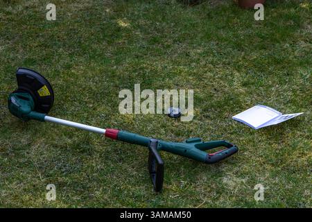 Rasaerba alimentato a batteria, rifinitore cordless posizionato sul prato, nuove attrezzature da giardino Foto Stock