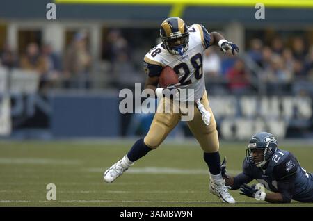 13 novembre 2005 - Seattle, WA, USA - il running back dei St. Louis Rams Marshall Faulk (28) rompe un tackle del cornerback dei Seattle Seahawks Andre Dyson (21) durante una partita al Qwest Field di Seattle, Washington. I Seahawks batterono i Rams 31-16. 13 novembre 2005. (Immagine di credito: © Troy Wayryen/ZUMAPRESS.com) Foto Stock