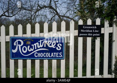 Cartello vintage che indica la Rownrtree's Chocolates e la Greenwich Meridian Line alla stazione di Sheffield Park - Bluebell Railway - East Sussex UK Foto Stock