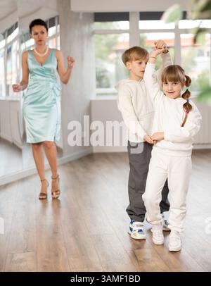 Ballerini Tween, ragazza e ragazzo che praticano il valzer in uno studio di danza Foto Stock