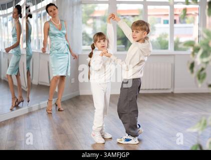 Ballerini Tween, ragazza e ragazzo che praticano il valzer in uno studio di danza Foto Stock