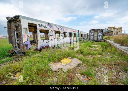 Carrozze ferroviarie passeggeri distrutte, fatiscenti e abbandonate accanto alla stazione ferroviaria in disuso nella città di Barreiro-Portogallo. Foto Stock
