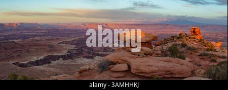 Questo panorama panoramico al tramonto dal quartiere Island in the Sky del Canyonlands National Park presenta il Gooseberry Canyon e la White Road sottostante. Foto Stock