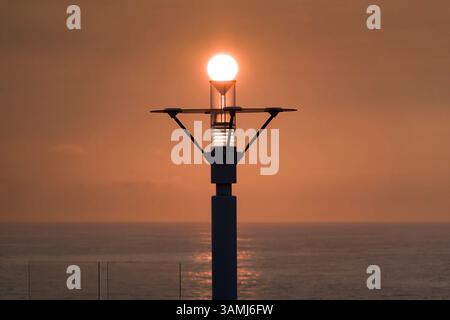 Allineamento perfetto: Corona del tramonto sulla lampada da crociera, momento catturato Foto Stock