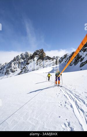 Scialpinismo con corda, team di corda sul ghiacciaio Vadret da Porchabella sulla salita alla vetta del Piz Kesch, paesaggio montano in inverno, alpino a. Foto Stock
