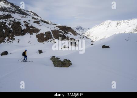 Sciatori in discesa al rifugio Grialetschhuette in inverno, percorso Grigioni Haute, Alpi Albula, Alpi Retiche, Grigioni, Svizzera, Europa Foto Stock