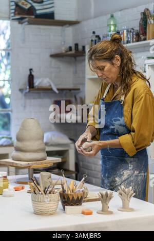 Artista appassionata al lavoro nel suo paradiso della ceramica Foto Stock