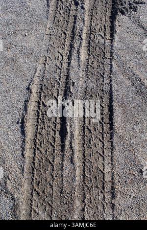 Primo piano sfondo testurizzato delle tracce degli pneumatici sulla sabbia Foto Stock