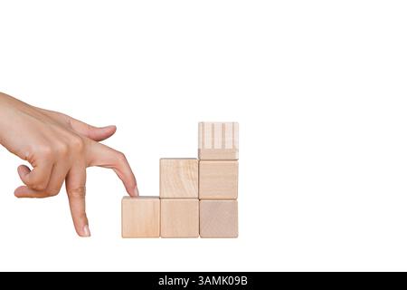 Le dita camminano su blocchi come scale per il concetto di affari e salire in anzianità. Le donne camminano con le mani su blocchi di legno impilati come scale Foto Stock
