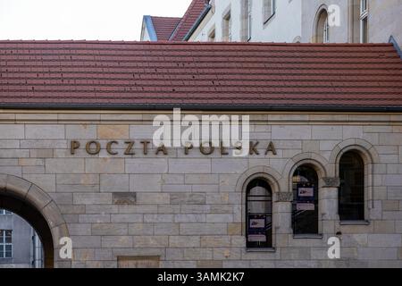 Poznan, Polonia - 8 aprile 2025: Vista dettagliata dell'edificio Poczta Polska con finestre ad arco, facciata in pietra beige e tetto piastrellato rosso, ripreso Foto Stock