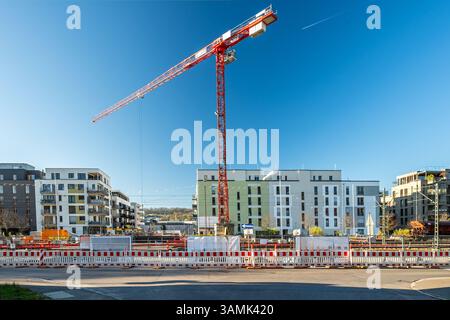 Cantiere con gru e recinzione di fronte a moderni edifici residenziali Foto Stock