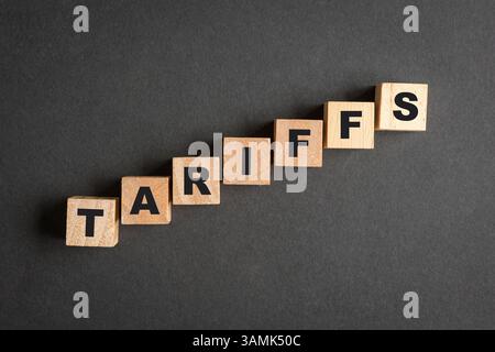 Tariffe, parola su blocchi di legno quadrati, impilati e in aumento. Foto Stock