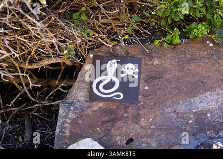 Teschio e ossa incrociate segnale di pericolo di serpenti velenosi nella zona del sentiero a Cape Point, Cape Peninsula, Cape Town, Western Cape, Sud Africa Foto Stock
