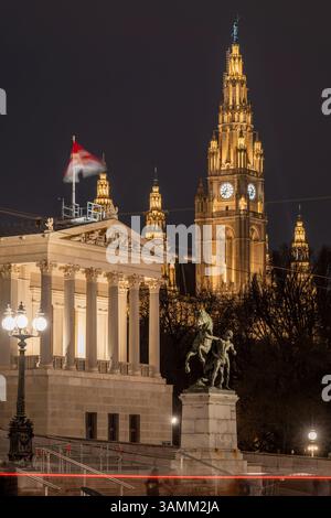Vista notturna dell'edificio del Parlamento austriaco e del Municipio di Vienna sullo sfondo, Vienna, Austria Foto Stock