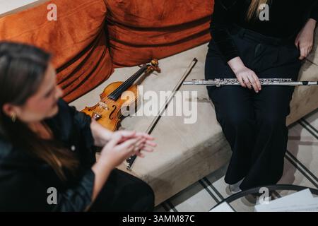 Giovani musicisti che studiano strumenti insieme in un accogliente ambiente interno Foto Stock