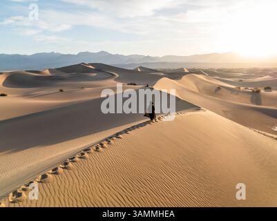 Vista aerea delle serene dune di sabbia al tramonto con una persona solitaria, Stovepipe Wells, California, Stati Uniti. Foto Stock