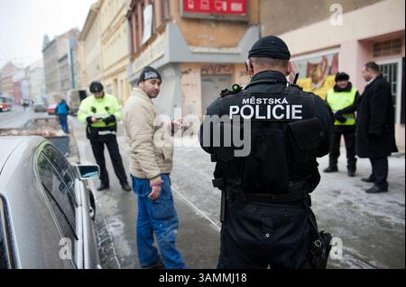 27 gennaio 2014 - Brno, Repubblica Ceca - Un ufficiale di polizia sta controllando i documenti di un uomo romeno. A causa del suo comportamento aggressivo, viene sorvegliato da diversi agenti di polizia. Questa parte problematica di Brno è popolarmente chiamata Bronx', da uno dei cinque distretti della città di New York. Questo sobborgo di Brno è una delle zone più povere della Repubblica ceca, con migranti principalmente romani coinvolti nel traffico illegale di droga. (Immagine di credito: © Hans Van Rhoon/ZUMA Wire/ZUMAPRESS.com) Foto Stock