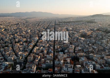Veduta aerea dello splendido paesaggio urbano con edifici storici e la fitta espansione urbana sotto il cielo del tramonto, Atene, Grecia. Foto Stock