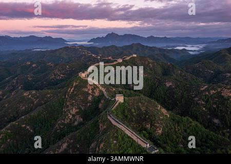 Vista aerea della grande parete di jinshanling che si snoda attraverso aspre montagne al tramonto, jinshanling, cina. Foto Stock