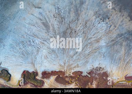 Vista aerea della formazione astratta di acqua lungo la costa del lago Elton, un grande lago salato con minerali a Vengelovskoe, Oblast' di Volgograd, Russia. Foto Stock