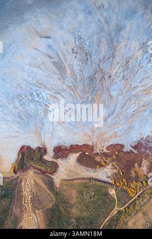 Vista aerea della formazione astratta di acqua lungo la costa del lago Elton, un grande lago salato con minerali a Vengelovskoe, Oblast' di Volgograd, Russia. Foto Stock