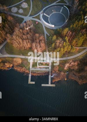 Vista aerea del tranquillo lago circondato da una foresta lussureggiante e sentieri panoramici, Elektrenai, Lituania. Foto Stock
