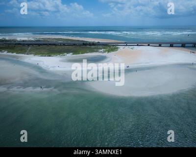 Vista aerea di una splendida spiaggia con sabbia colorata e gente vicino a un ponte e una strada, St. Augustine, Stati Uniti. Foto Stock