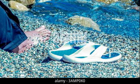 Spagnolo - Andalusia-Fruehling-aprile 2025 fuss im Wasser des Mittelmeer Stein Strand mit Sandalen Andalusien ist eine große autonome Region Spaniens an der Südküste des Landes. Die Landschaft wird von Hügeln, Flüssen und der Landwirtschaft bestimmt Andalusien Spanien *** Spagna Andalusia primavera aprile 2025 piedi nelle acque del Mar Mediterraneo spiaggia di pietra con sandali Andalusia è una grande regione autonoma della Spagna sulla costa meridionale del paese il paesaggio è caratterizzato da colline, fiumi e agricoltura Andalusia Spagna Foto Stock