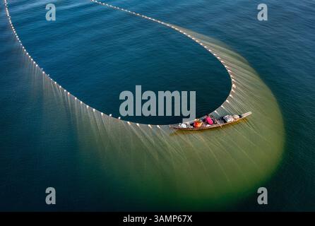 Vista aerea della pesca con un'enorme rete da una barca sopra la splendida acqua, Jibtali Union, Rangamati, Chattogram, Bangladesh. Foto Stock