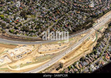 Vista aerea del quartiere suburbano con case e cantieri lungo l'autostrada, Greensborough, Australia. Foto Stock
