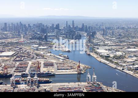 Veduta aerea del vasto paesaggio urbano con grattacieli e un porto fluviale pieno di container, Yarraville, Victoria, Australia. Foto Stock