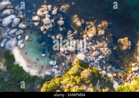 Vista aerea di una spiaggia isolata con massi e sabbia bianca, città del Capo, Sud Africa. Foto Stock