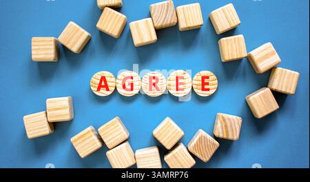 Simbolo di accordo. La parola concettuale è d'accordo su bei cerchi di legno. Splendido sfondo blu da tavolo. Bellissimi cubetti di legno. Il concetto di business è d'accordo. Co Foto Stock