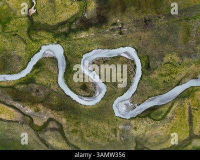 Veduta aerea di un tortuoso fiume che trasporta sedimenti dal ghiacciaio, la valle preda Rossa, la Val Masino, Italia. Foto Stock