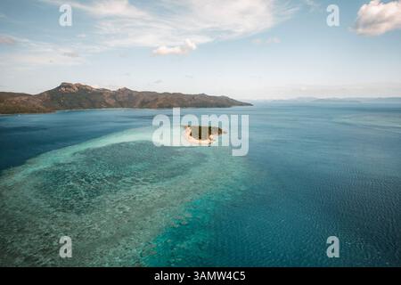 Vista aerea di Black Island con la barriera corallina che si estende lontano e Hook Island visibile in lontananza, Whitsundays, Australia. Foto Stock