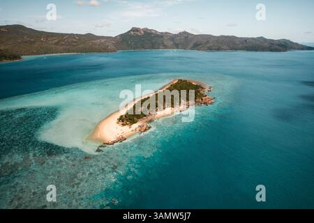 Vista aerea di Black Island con la barriera corallina che si estende lontano e Hook Island visibile in lontananza, Whitsundays, Australia. Foto Stock