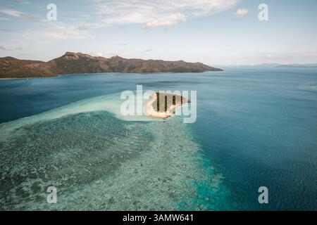 Vista aerea di Black Island con la barriera corallina che si estende lontano e Hook Island visibile in lontananza, Whitsundays, Australia. Foto Stock