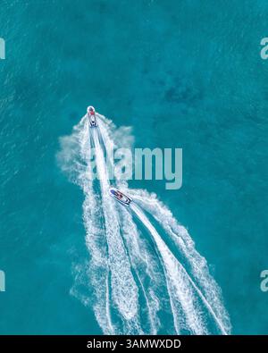 Veduta aerea dall'alto verso il basso delle persone sulle moto d'acqua nelle onde dell'Oceano Blu a male, Maldive. Foto Stock