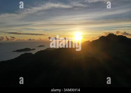 Vista aerea del sole che tramonta dietro Mahé, Seychelles Foto Stock