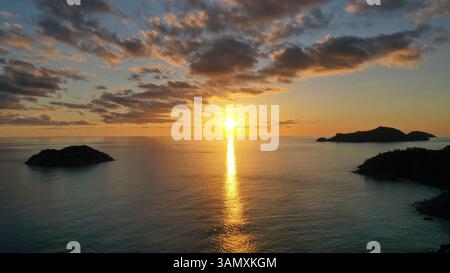Vista aerea del sole che tramonta dietro Therese e Conception Island da Mahé, Seychelles. Foto Stock