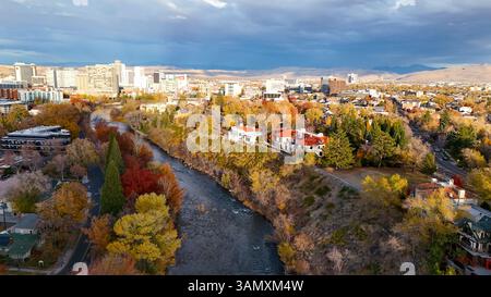 Veduta aerea delle vibranti foglie autunnali e del tranquillo fiume tra edifici urbani e skyline, Reno, Stati Uniti. Foto Stock