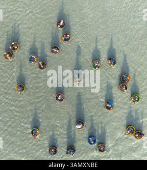 Vista aerea del tour in barca con le noci di cocco con turisti in bamboo intorno a splendide acque, Hoi An, Vietnam. Foto Stock