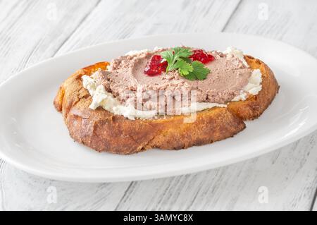 Sandwich di grano tostato con patè, formaggio cremoso e marmellata di mirtilli rossi Foto Stock
